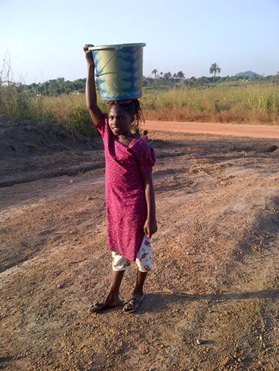 Little girl carrying water from the well