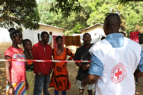A psychosocial assistant volunteer visits a household under quarantine during the Ebola epidemic