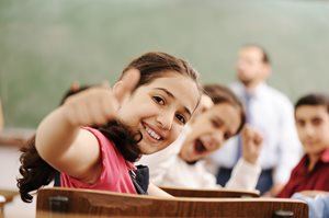 Student gives thumbs up in a classroom