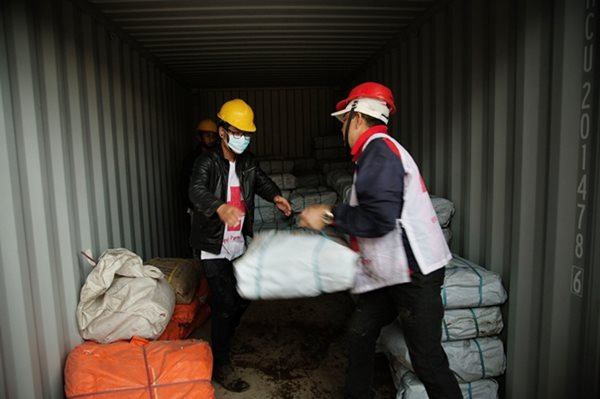 Red Cross volunteers load tarpaulins to be delivered to those who need shelter