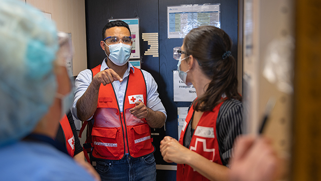 Multiple Canadian Red Cross persons wearing protective eyewear and surgical masks.