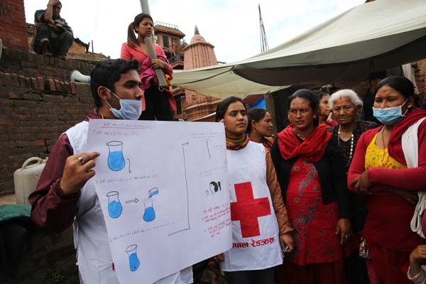 Nepal Red Cross volunteer shows a drawing on how to use tablets