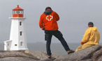 A Canadian Red Cross employee taking photos of a lighthouse