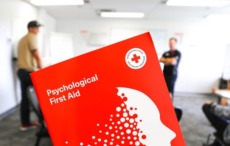 A close-up of a red booklet with title: Psychological First Aid