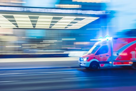 Ambulance speeding through city street with blur effect