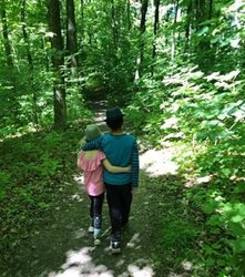 Two children walking through a forest.