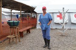 Katherine Mueller standing in the low risk area inside the Ebola treatment centre in Kenema, Sierra Leone. Behind her is the tent where health care workers take off their personal protective equipment.