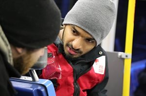 Ashwin, in a Red Cross vest and grey toque, talking to someone.
