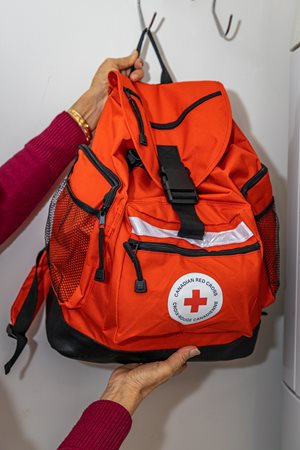 A Canadian Red Cross emergency backpack hung on a hook