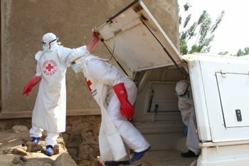 Red Cross team members exiting a Red Cross van dressed in full personal protective equipment (PPE)