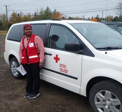 Volunteer Ibtesam Eisa in front of Red Cross van