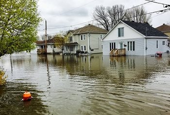 A street lined with houses flooded with high waters