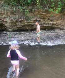 Two children playing in a creek