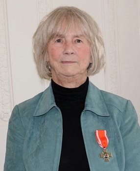 A headshot of a woman wearing the Order of the Red Cross medal on her shirt