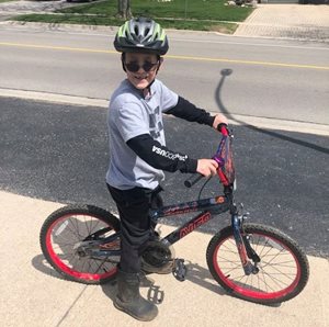 Aidann on his bike with helmet on ready to go