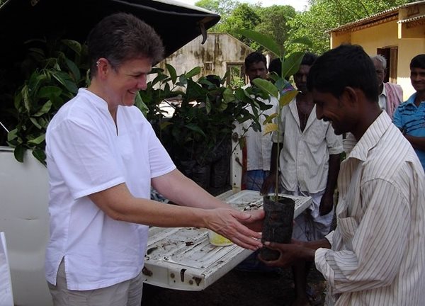 Pat distributing fruit tree seedlings to recipients of CRC constructed houses in Sri Lanka
