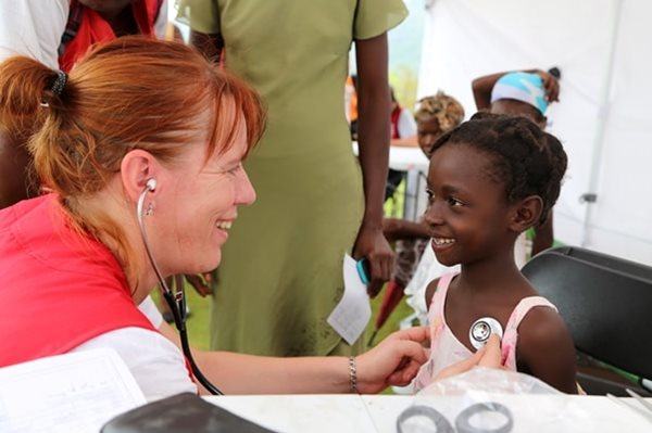 French Red Cross doctor Aleth Abidine examines young girl at a mobile clinic