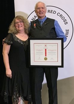 Garry Jacobs holding his Order of the Red Cross pictured with his wife Sandy