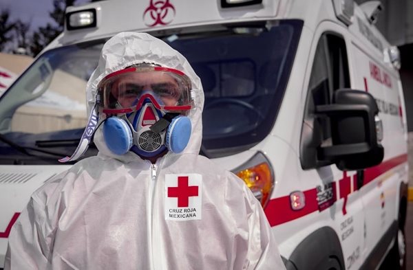 A man in personal protective equipment standing in front of an ambulance in Mexico
