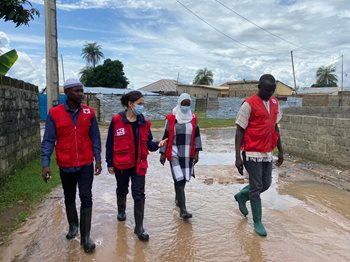 Sarah Parisio walking with 3 Red Cross members on a flooded street