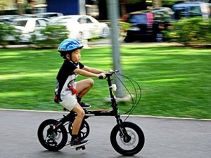 A little boy on a bike wearing a helmet