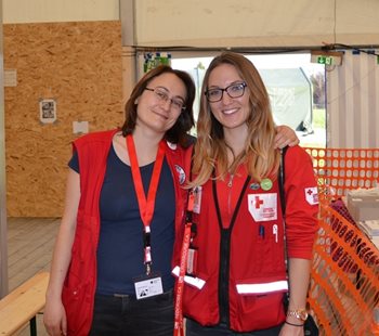 Two women in Red Cross vests smiling at the camera