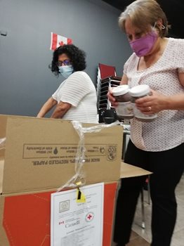 Maha Khedher (L) and Zamrud Hassan help prepare food boxes for distribution to vulnerable Arabic-speaking families. They are board members of the Iraqi Canadian Society, a non-profit which is using funds from the Canadian Red Cross to support those in need during COVID-19