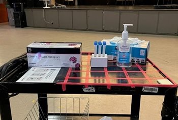 A testing station, including swabs, gloves, on a table in front of a theatre stage