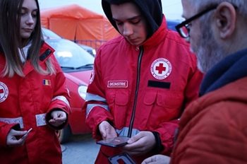 Romanian Red Cross team members gathered on their phones