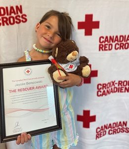Six-year-old Jayce holding her Canadian Red Cross teddy bear and Rescuer Award