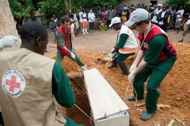 Jean-Baptiste and other Red Cross members help complete a dignified burial of someone who died from Ebola